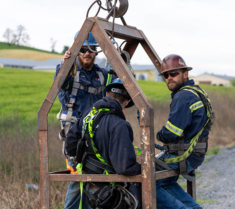 Millwright team awaiting a lift in a crane