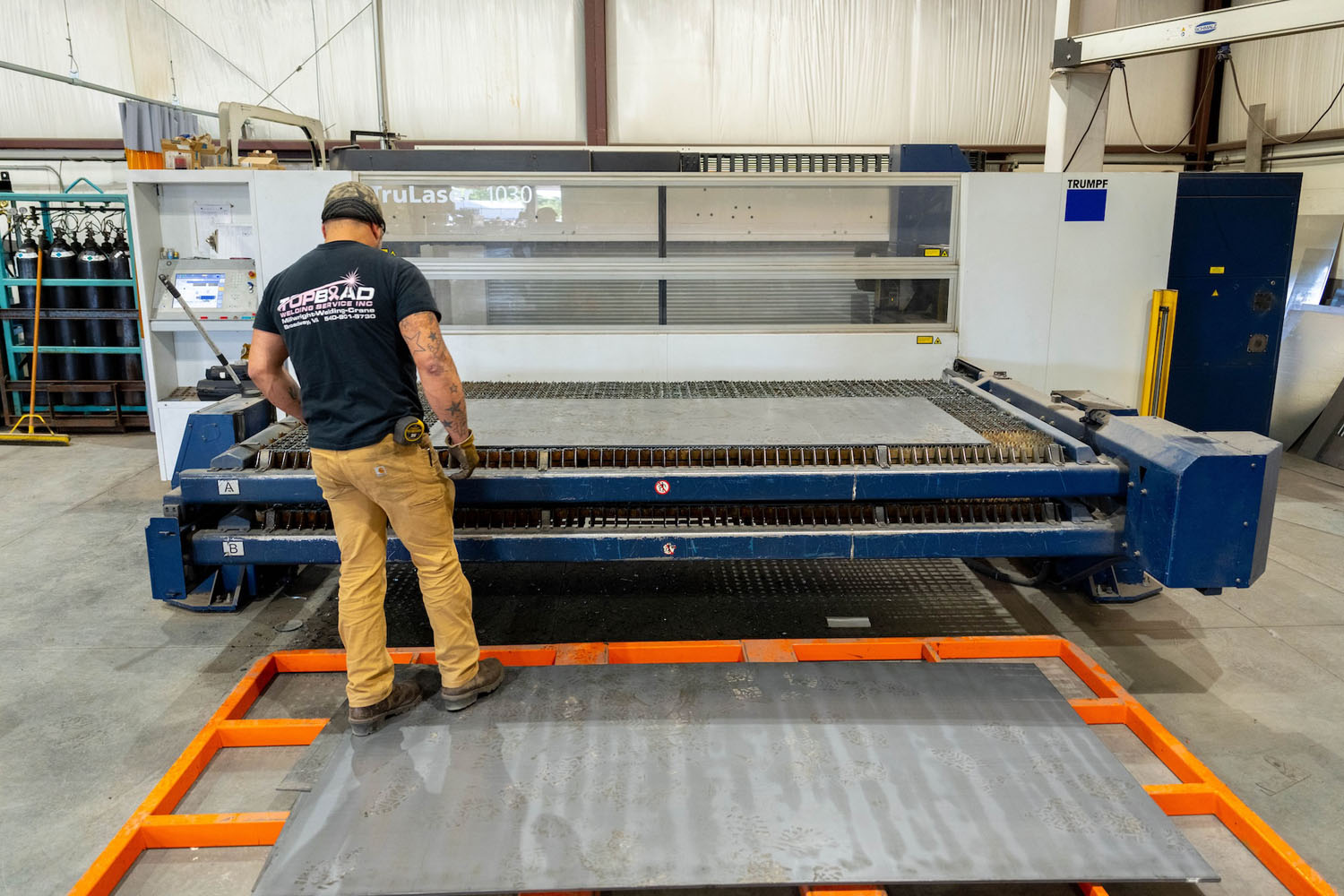 Metalworker cutting sheet metal on a plasma cutter