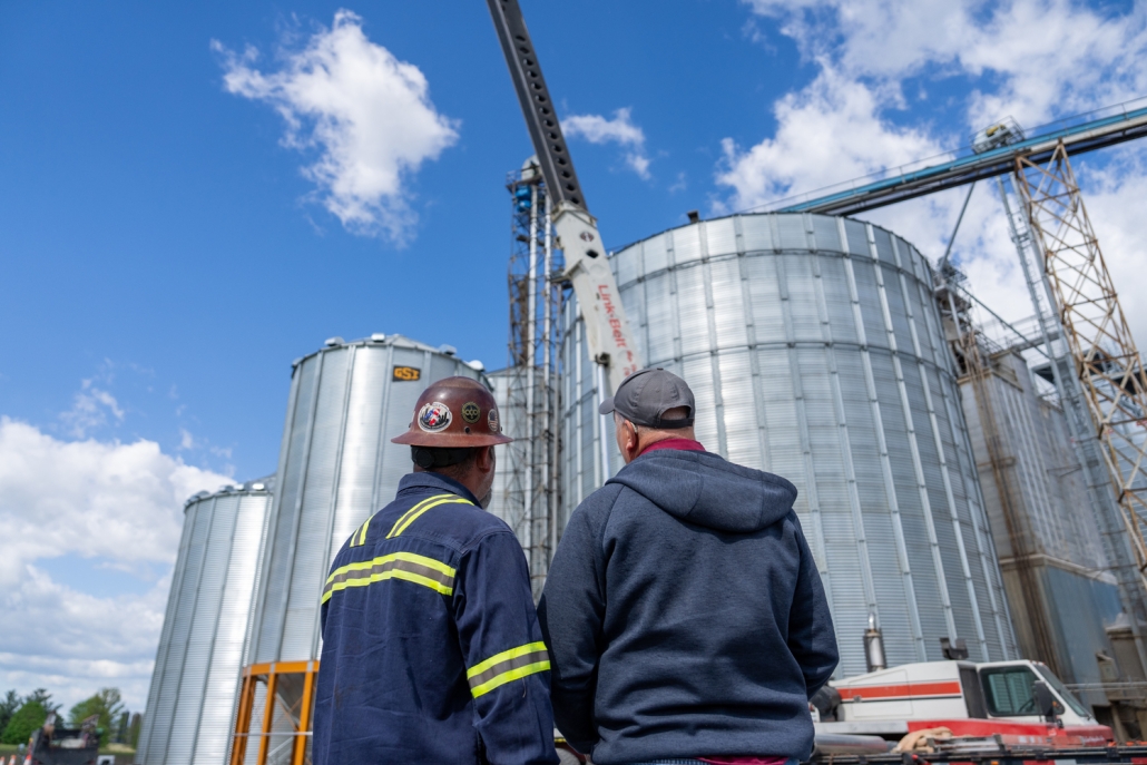 contractors looking up at a silo