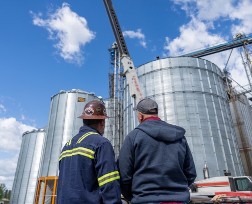 contractors looking up at a silo